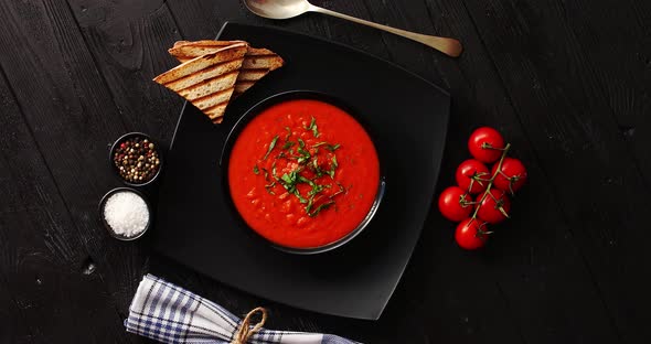 Tomato Soup in Black Bowl with Crisp Bread 