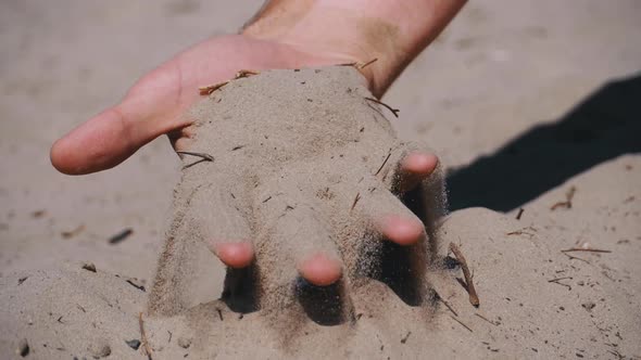 Sand Falls From a Man s Hand on the Beach in Slow Motion. Dirty Sand in Hand of Men