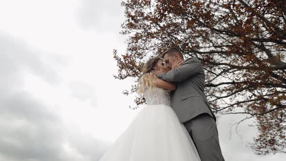 Lovely Young Newlyweds Bride Groom Embracing on Cloudy Sky Background Wedding Couple Family in Love