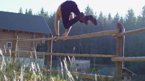 Young man jumping  a fence