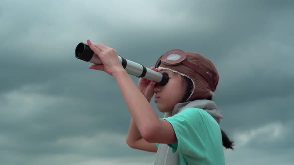 Asian child girl looking in spyglass, Happy kid playing outdoors