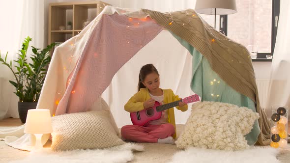 Girl with Toy Guitar Playing in Kids Tent at Home