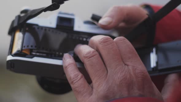 Hiker Preparing Vintage Slr Camera With Film