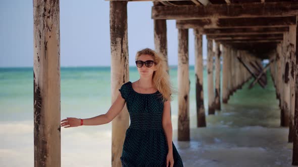 Girl In Summertime Season Sundress Leisure. Walking On Coastline And Hair Blowing On Wind.