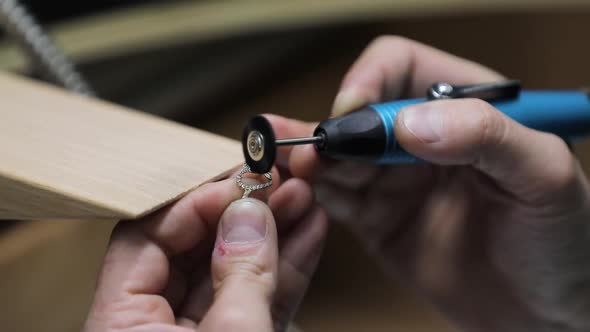 eweller sitting at desk and making jewelry in workshop