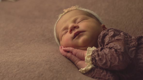 Little Beautiful Caucasian Girl in Elegant Clothes Sleeps in the Studio and Poses for a Photo Shoot