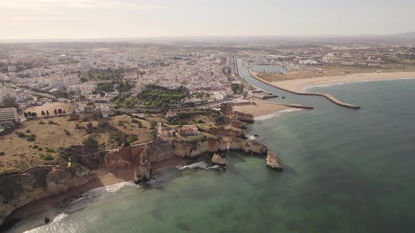 Cinematic broll aerial coastal city view of Lagos Algarve Portugal.