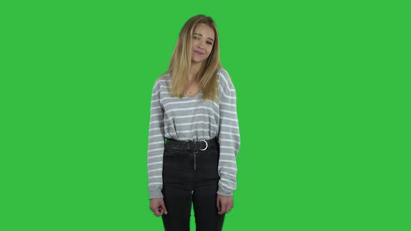 Cute Blonde Girl with Long Hair Is Posing on a Green Screen