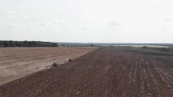 Agricultural machinery plowing fields after harvesting. Tractors working on fields.