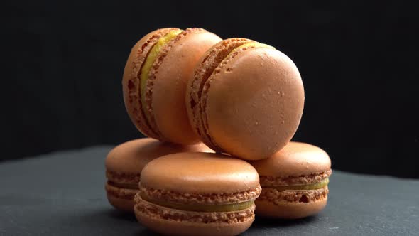Macaroon Rotate on a Black Background and Hand Adds a Cake and Candy Sweets are Spinning Macro