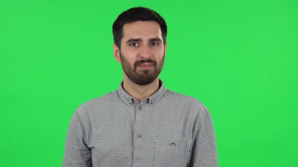 Portrait of Brunette Guy Communicates with Someone in a Friendly Manner. Green Screen