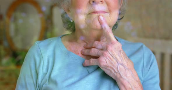 Senior woman looking through the window 4k