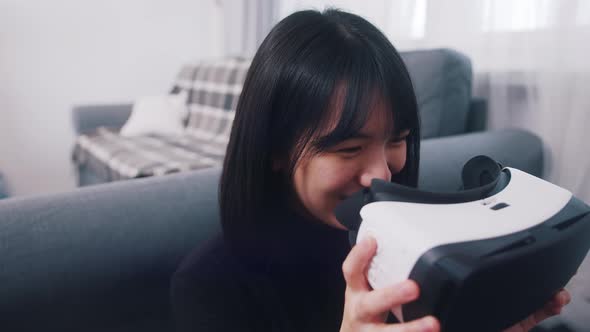 Young Asian Woman Putting on VR Glasses
