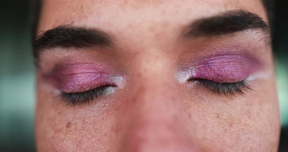 Close up of young transgender man with makeup looking on camera outdoor