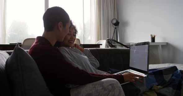 Lesbian couple using laptop in living room
