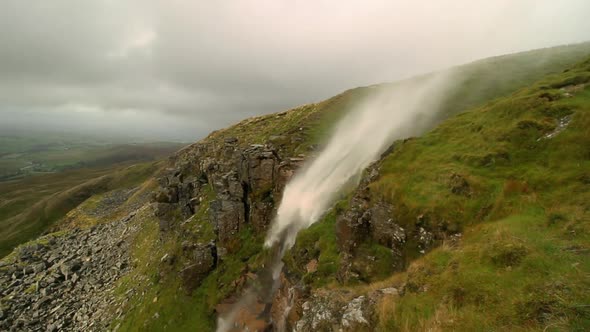 Waterfall high on Mallerstang Edge in Cumdria being blown upwards or inverted by the strong wind. As