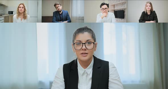 Serious lady in glasses talks to bored corporate colleagues