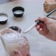 Female Potter Sitting and Stirs Paint with a Brush a Cup on the Table. Woman Making Ceramic Item - VideoHive Item for Sale