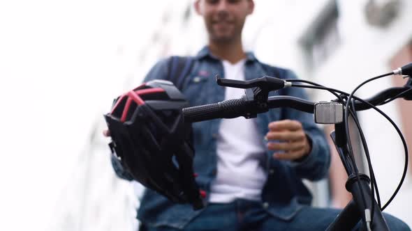 Lowangle View of Handsome Cheerful Young Courier Male with Large Thermo Backpack Taking Off