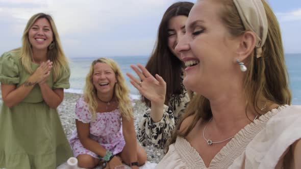 Videocall From Four Happy Female Friends Having a Picnic on the Beach