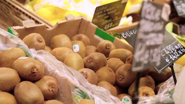 Picking kiwi fruit in the market at slow motion. Buying organic healthy food at fruit shop grocery s