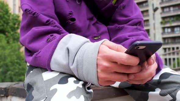 Detail of man's hand using smartphone in city