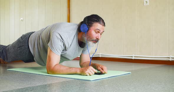 Dolly Shot of a Middle Aged Man During Plank Workout