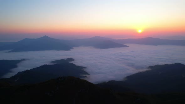 A sea of clouds above the valley and the mountains in the background. 4K Aerial video