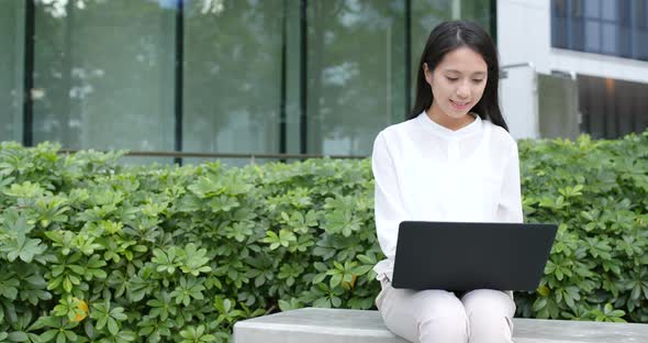 Business woman use of notebook computer at city