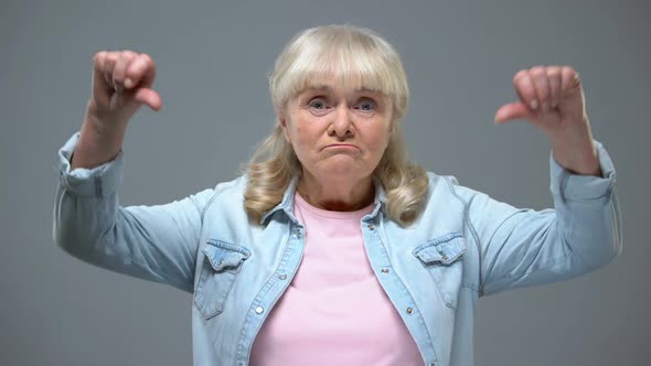 Funny Elderly Female Showing Thumbs-Down Gesture, Unhappy With State Government