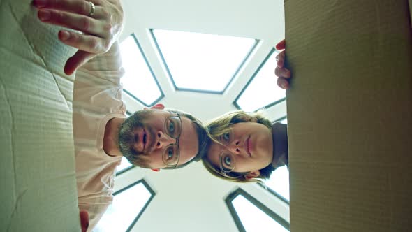 the Couple Opens Cardboard Box and the Man is Happy and Surprised the Woman Sad is Not Happy with