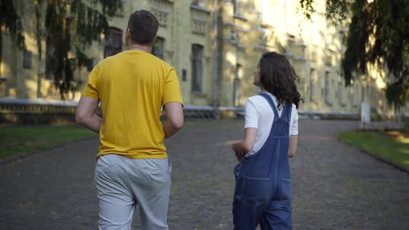 Tracking Shot of Caucasian Groupmates Talking Walking at University Campus in the Morning