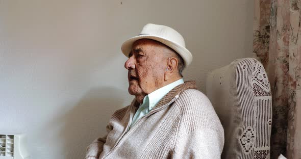 Elderly man talking alone at home