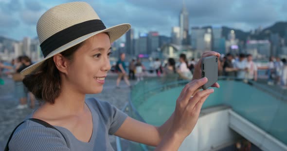 Woman use of mobile phone to take photo in city of Hong Kong