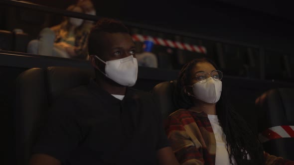 African American Couple Enjoying Film During Pandemic Wearing White Face Masks