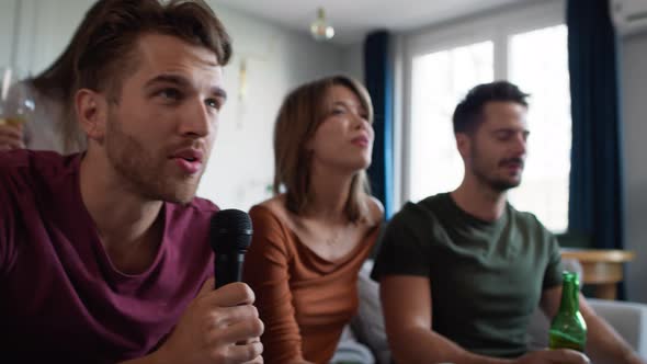 Young adult friends singing at home karaoke. Shot with RED helium camera in 8K