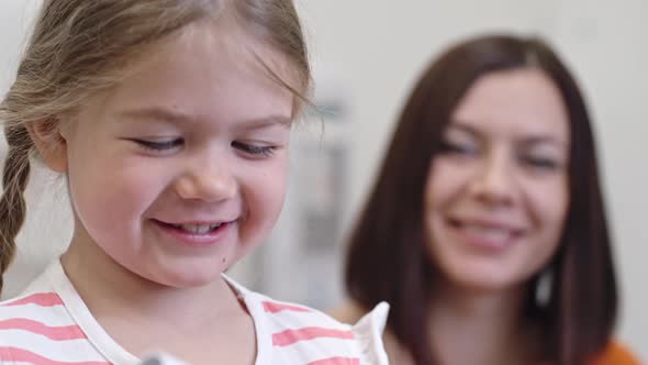 Smiling Little Girl Blowing into Breathalyzer