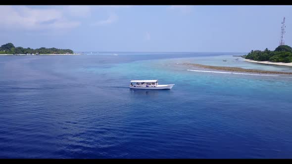 Aerial drone view scenery of marine shore beach journey by blue lagoon with white sandy background o