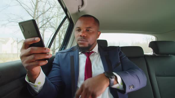 Positive Male Entrepreneur Typing Text Message on Phone in Car