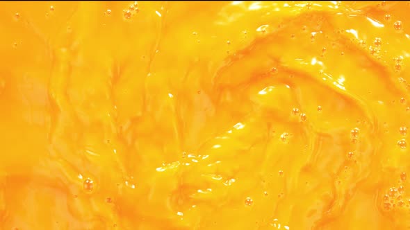 Super Slow Motion Shot of Swirling Fresh Orange Juice Background at 1000 Fps