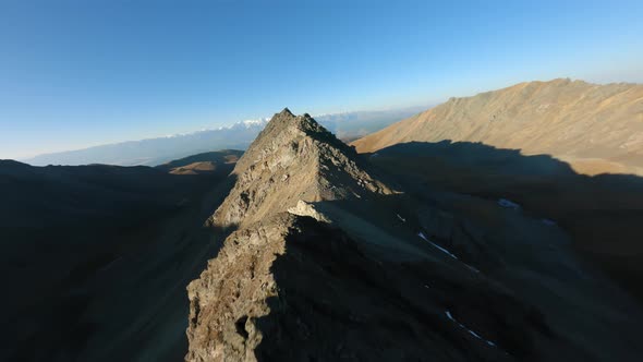 FPV Sports Drone Flight Natural Mountain Ridge Stone Structure at Sunlight Glare Blue Sky Panorama