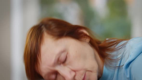 Live Camera Follows Sad Exhausted Mature Woman Putting Head on Table Indoors