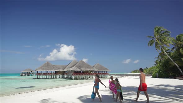 Family With Kids Walking Across the Beach