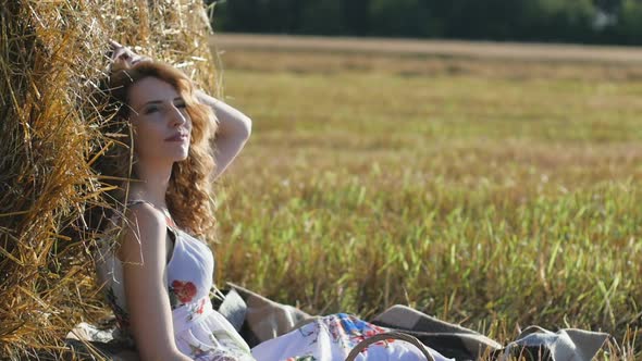 Closeup Portrait of Attractive Young Redhead Woman Sitting Near Hay