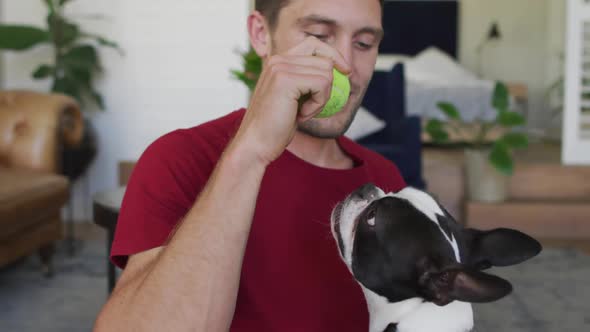 Caucasian man is playing with his dog at home