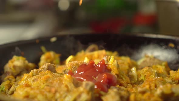 Frying pan with meat and vegetables close-up.