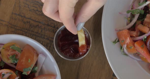 Eating french fries with ketchup dip sauce