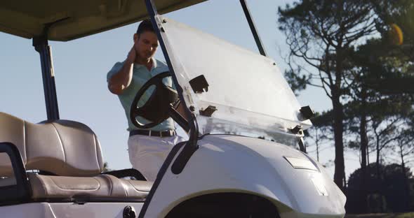 Golf player getting into golf buggy