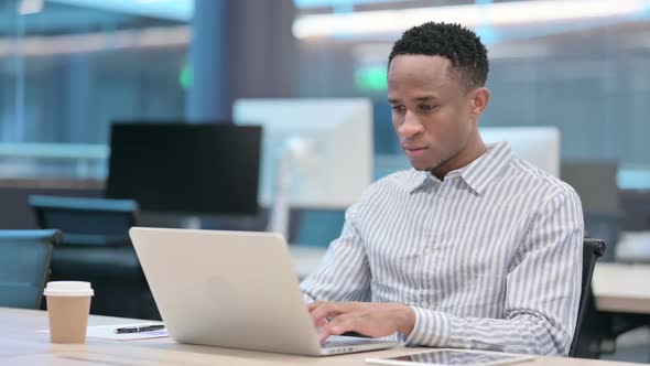 Young African Businessman Working on Laptop in Office