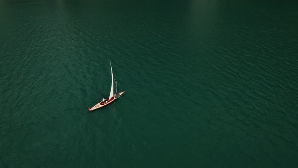 A Sailboat Floats on a Picturesque Lake at the Foot of the Alpine Mountains